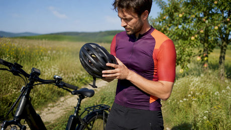 Un homme règle son casque de vélo avant de partir pour une balade en plein air.