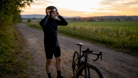 Un cycliste ajuste son casque équipé de multiples accessoires.