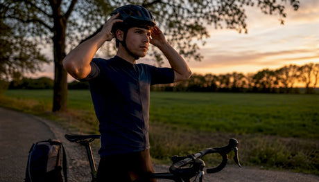 Un cycliste prend quelques instants sur un banc en ville pour régler son casque MIPS.