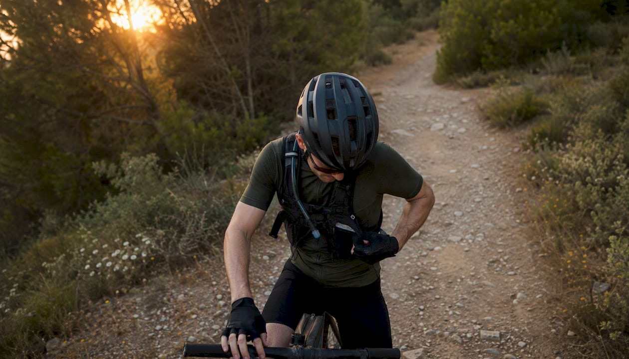 Cyclist adjusting gloves on gravel trail ride