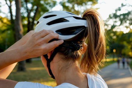 Cyclist adjusting bike helmet with ponytail