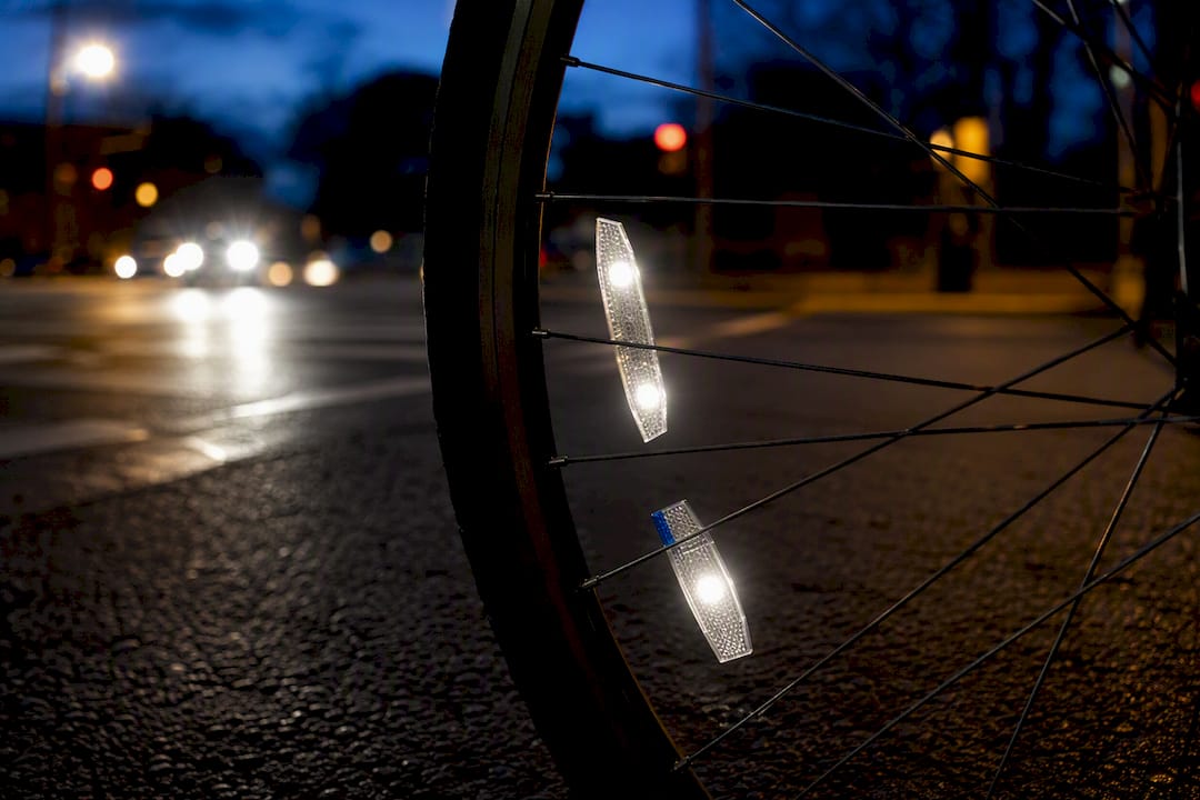 Wheel reflectors flashing at dusk intersection