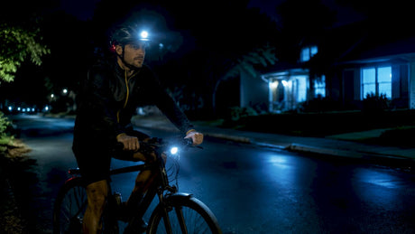 Cyclist in city wearing helmet with integrated lights