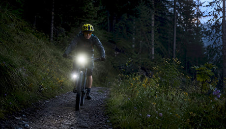Cyclist with adaptive bike lights riding at dusk