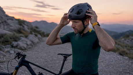 Male cyclist adjusting sensor helmet outdoors