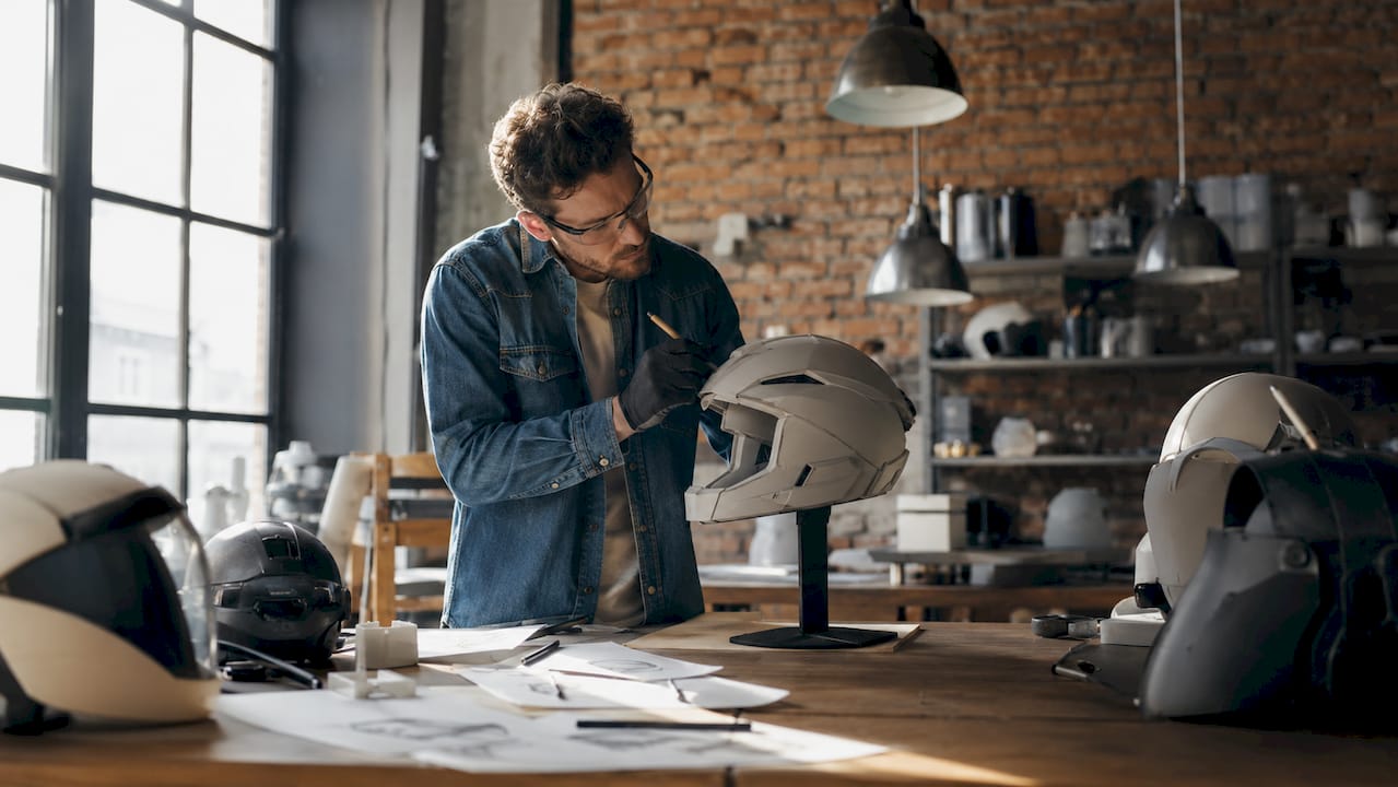 Un designer s’affaire à dessiner les premières esquisses d’un casque au look résolument futuriste.