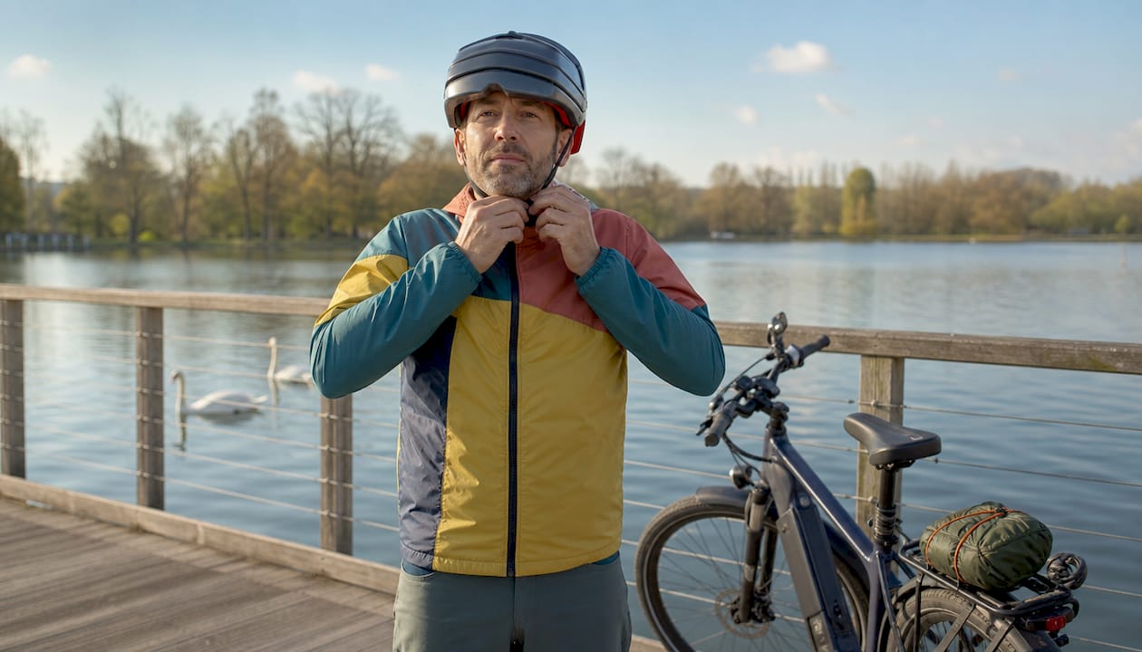 Un cycliste ajuste son casque pliable avant de partir en balade.