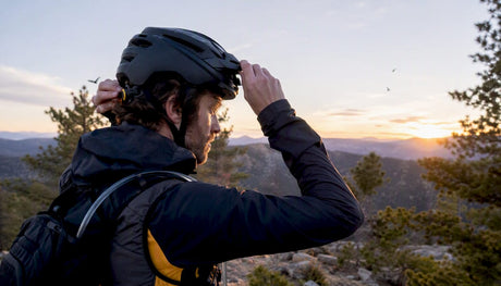 Bikepacker adjusting mountain bike helmet outdoors