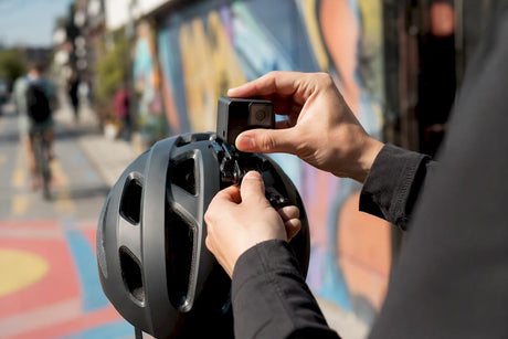Hands adjusting helmet camera outdoors