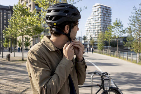 Cycliste ajustant la sangle de son casque de route