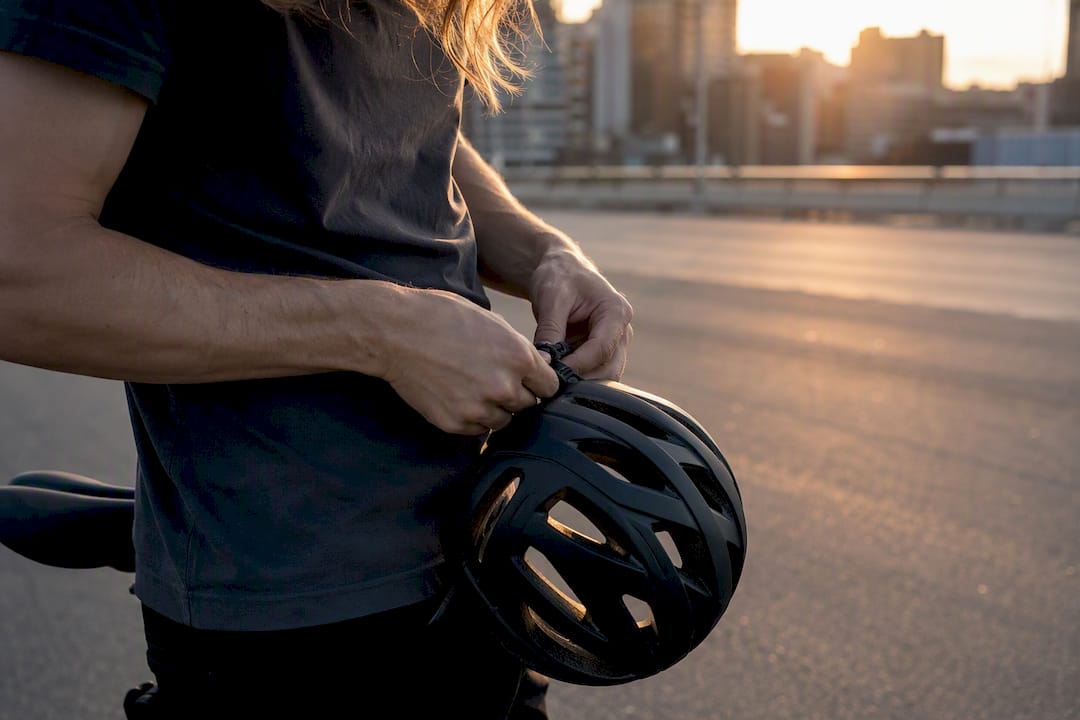 Cycliste ajustant les sangles d'un casque ventilé