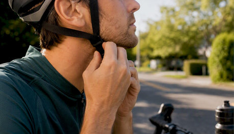 Cycliste ajustant la sangle de son casque en extérieur