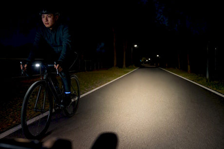 Cyclist riding beneath a controlled night beam