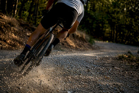 Cycliste sur gravel prenant un virage caillouteux